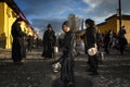 Young boy wearing a black robe spreading incense in a street of the city of Antigua during a procession of the Holy Week in Antigu