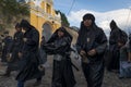 Young boys wearing black robes and hoods spreading incense in a street of the city of Antigua during a procession of the Holy Week