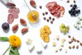 Antipasti food white flat lay with nuts, honey, cured meat, salami, cheeses, grapes and figs.