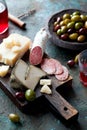 Antipasto board with sliced salami, goat cheese, assorted olives and red wine Royalty Free Stock Photo