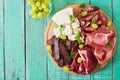 Antipasto catering platter with bacon, jerky, sausage, blue cheese and grapes Royalty Free Stock Photo