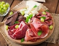 Antipasto catering platter with bacon, jerky, sausage, blue cheese and grapes Royalty Free Stock Photo