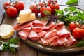 Antipasto with ham, bresaola and salami. bread, tomato and basil Royalty Free Stock Photo