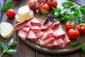 Antipasto with ham, bresaola and salami. bread, tomato and basil Royalty Free Stock Photo