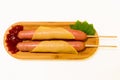 Antipasto platter boiled Frankfurter sausages with sauce on a wooden plate with cheese and mint over white background. Appetizer,