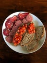 Antipasto platter cold meat plate with bread prosciutto slices salami and tomato in wood background