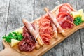 Antipasto platter cold meat plate with grissini bread sticks, prosciutto, slices ham, beef jerky, salami and arugula on board Royalty Free Stock Photo
