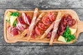 Antipasto platter cold meat plate with grissini bread sticks, prosciutto, slices ham, beef jerky, salami and arugula Royalty Free Stock Photo