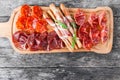 Antipasto platter cold meat plate with grissini bread sticks, prosciutto, slices ham, beef jerky, salami and arugula Royalty Free Stock Photo