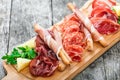 Antipasto platter cold meat plate with grissini bread sticks, prosciutto, slices ham, beef jerky, salami and arugula Royalty Free Stock Photo