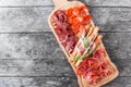 Antipasto platter cold meat plate with grissini bread sticks, prosciutto, slices ham, beef jerky, salami on cutting board Royalty Free Stock Photo