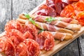 Antipasto platter cold meat plate with grissini bread sticks, prosciutto, slices ham, beef jerky, salami on cutting board Royalty Free Stock Photo