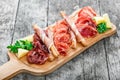 Antipasto platter cold meat plate with grissini bread sticks, prosciutto, slices ham, beef jerky, salami on cutting board Royalty Free Stock Photo