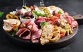 Antipasto platter with ham, prosciutto, salami, blue cheese, mozzarella with pesto and olives