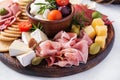 Antipasto platter with ham, prosciutto, salami, cheese, crackers and olives on a light background. Royalty Free Stock Photo