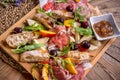 Antipasto platter with ham, prosciutto, salami, cheese, crackers and olives on a wooden background Royalty Free Stock Photo
