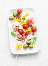 Antipasto skewers. Mediterranean appetizer to wine - prosciutto, bell peppers, cherry tomatoes, mozzarella cheese on skewers. Deli Royalty Free Stock Photo