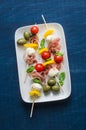 Antipasto skewers. Mediterranean appetizer to wine - prosciutto, bell peppers, cherry tomatoes, mozzarella cheese on skewers. Deli Royalty Free Stock Photo