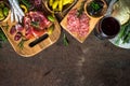 Antipasto - sliced meat, ham, salami, olives on dark stone table top view.