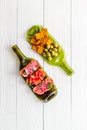 Antipasto on wine bottles on white wooden table top-down Royalty Free Stock Photo