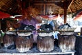 Man cooks Filipino delicacy called Bibingka or ground glutenous rice in clay pots Royalty Free Stock Photo