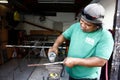 Worker at a steel fabrication shop grind and smooth out a steel rod Royalty Free Stock Photo