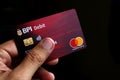 Hand holding a debit or ATM Mastercard with EMV chip of BPI