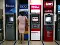 A woman withdraws money from a bank ATM at a commercial center