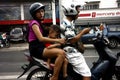 Filipino couple with their children ride a motorcycle and wait for the green light at an intersection of a major road