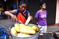 Street vendor sells freshly cooked corn on a cob on his food cart