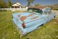 An antique abandoned 1955 Ford in front yard of house near Barstow, CA off of Route 58