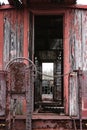 Antique, abandoned train car in a field in Pennsylvania. The paint is peeled and faded.