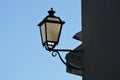 Antique lamppost lantern attached to wall of building. Light off. 