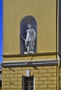 Antique ancient sculpture stands on the facade in wall of yellow building of Russian State Academic Drama Theater