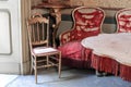 Antique armchairs in pure gold and torn red silk