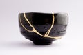 Antique beautiful broken raku bowl restored with kintsugi gold technique Royalty Free Stock Photo