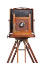 Antique bellows style camera front view close up on an old tripod isolated on white Royalty Free Stock Photo