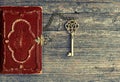 Antique bible book and golden key on wooden background