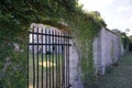 Iron Gate Leading to Secret Garden in Stone Wall with Climbing Vines