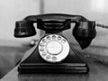 Antique black rotary telephone on a wooden desk. Royalty Free Stock Photo