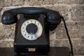 Old telephone with a dial on the background of a brick wall. Royalty Free Stock Photo