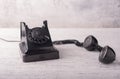 Antique black telephone with off-hook for a call, on a wooden table with white shabby paint. Royalty Free Stock Photo