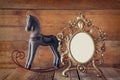 Antique blank victorian style frame and old rocking horse over wooden table