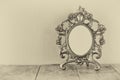 Antique blank victorian style frame on wooden table. black and white style photo. template, ready to put photography