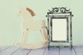 Antique blank vintage style frame and old rocking horse over woo Royalty Free Stock Photo