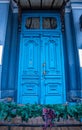 Antique blue door with ornate brass handle and distressed wooden panels Royalty Free Stock Photo