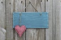 Antique blue sign hanging on wood door with gingham heart