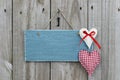 Antique blue sign hanging on wood door with hearts and iron key