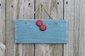 Antique blue sign hanging on wood door with soda pop tops