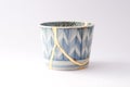 Antique blue and white cup repaired with the antique kintsugi real gold technique Royalty Free Stock Photo